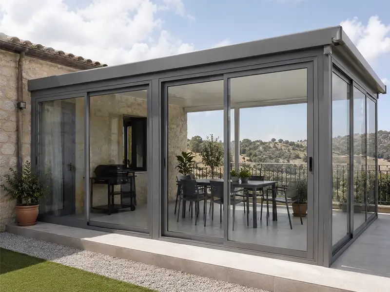 Cerramiento de PVC con puertas correderas de cristal instalado en el jardín de una vivienda en Antequera, Málaga.
