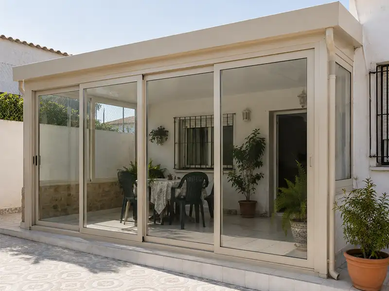 Cerramiento de terraza con estructura de PVC y aluminio y puertas correderas de cristal instalado en una vivienda de Vélez-Málaga.