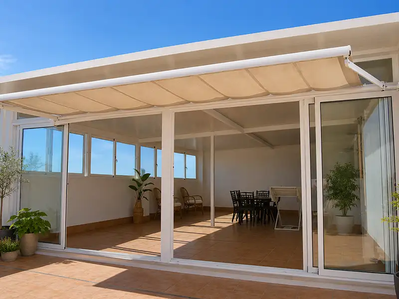 Cerramiento de terraza con cortinas de cristal y estructura de aluminio instalado en vivienda en Málaga.