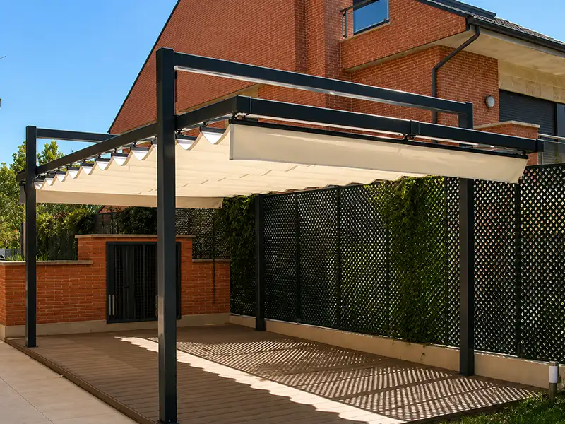 Estructura pérgola con palillería toldo corredero instalada en jardín de vivienda en Málaga.