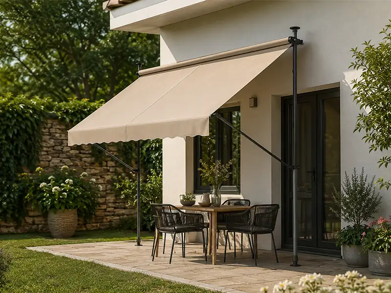 Toldo de brazos articulados con patas telescópicas instalado en el jardín de una vivienda en Granada para crear una zona de sombra confortable.