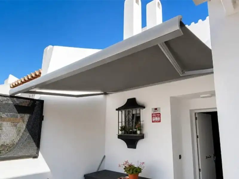 Toldo articulado con cofre en la Costa de Granada con lonas grises