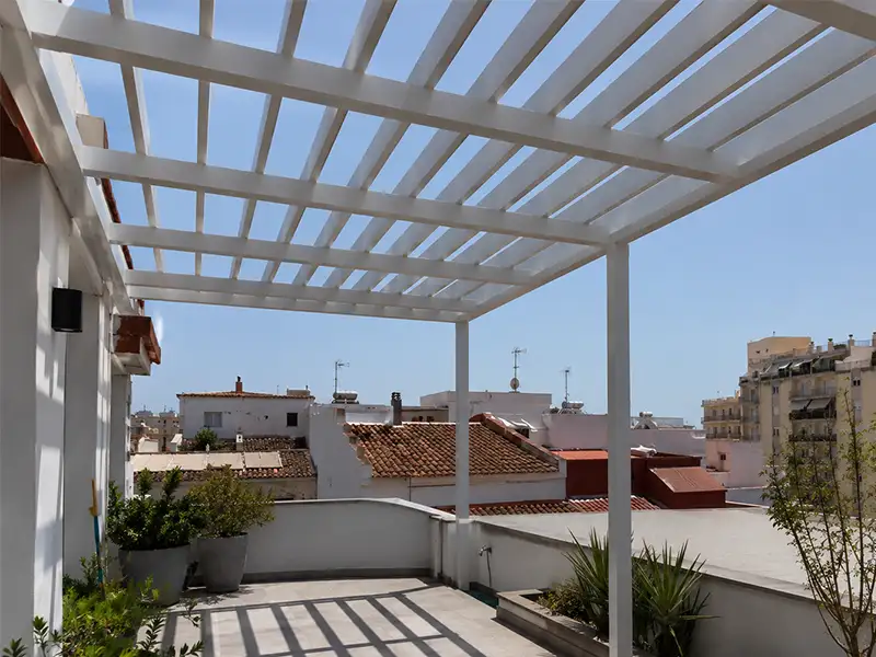 Pérgola de aluminio con estructura fija instalada en una terraza, diseñada para incorporar protección solar a medida y crear un espacio exterior funcional.