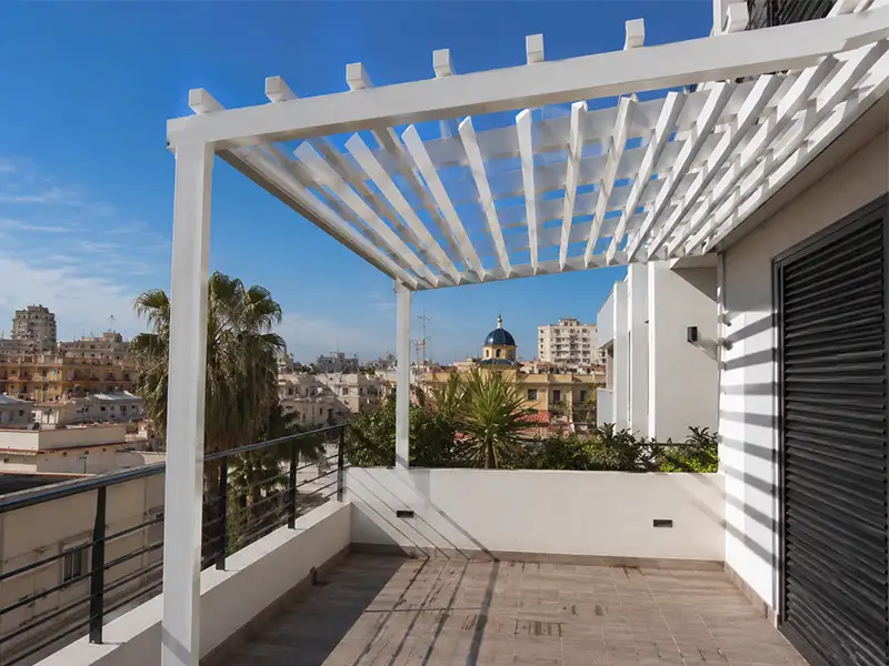 Pérgola de aluminio con palillería fija instalada en una terraza de Málaga, proporcionando sombra y un diseño moderno con vistas panorámicas de la ciudad.