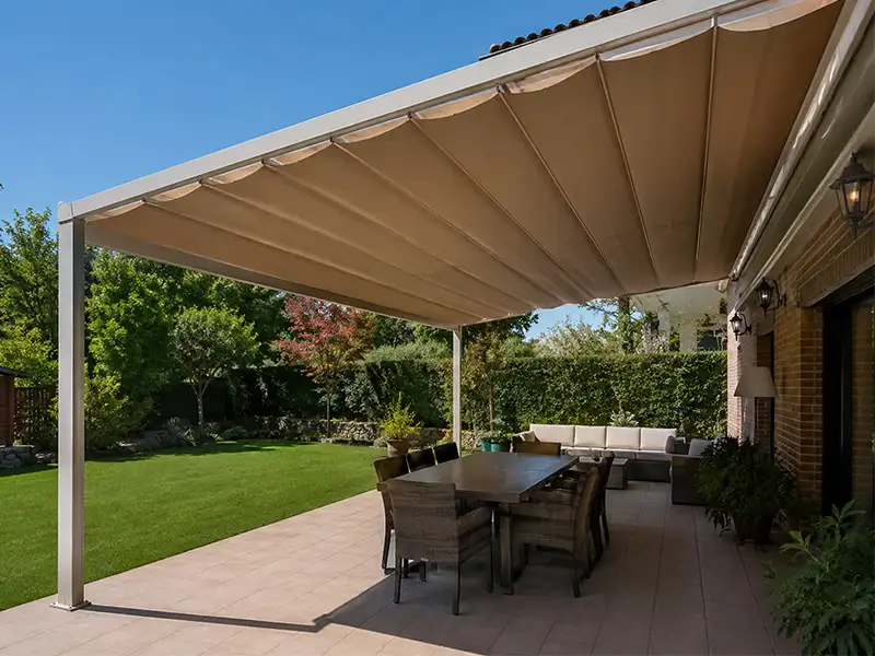 pérgola de estructura con palillería móvil con lona de color arena en jardín una vivienda de Málaga