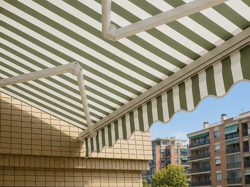 toldo articulado en Málaga con lona blanca y rayas verdes en balcón