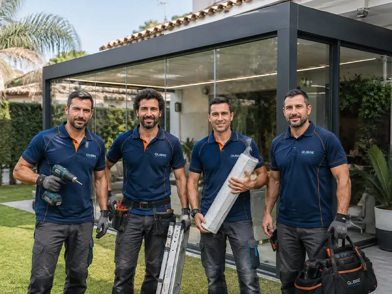 equipo de instaladores de Qubre empresa de toldos y pérgolas en Málaga y la Costa de Granada terminando de la instalación de un cerramiento