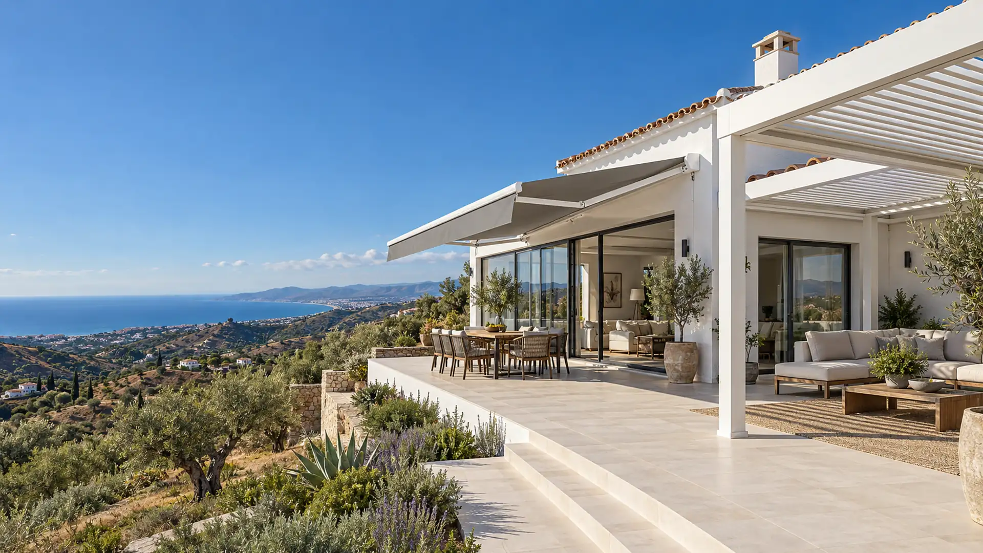 Servicios de toldos y pérgolas en Málaga Servicios de toldos y pérgolas: toldo articulado y pérgola bioclimática de lamas en la terraza de un chalet de la Axarquía con vistas al mar