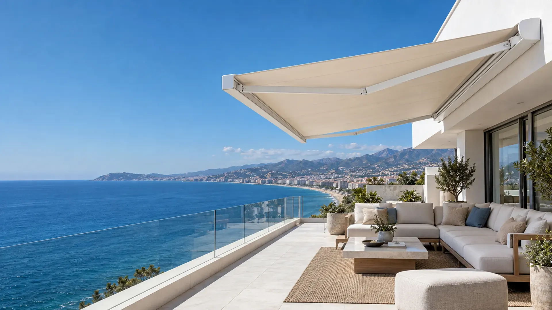 Toldo cofre en Málaga Toldo cofre en Málaga con lona beige extendido en un ático en primera línea de playa con vistas a la bahía