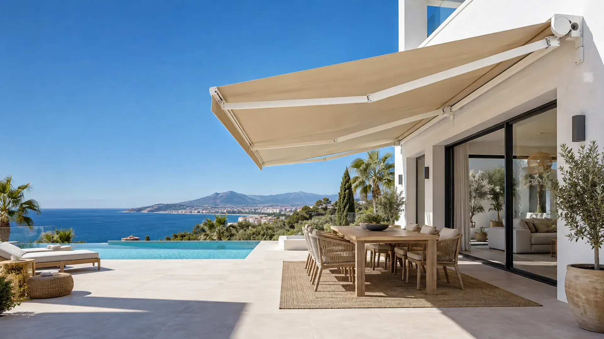 Toldo monobloc en Málaga Toldo monobloc en Málaga: toldo de gran tamaño con lona color arena sobre el comedor exterior de un chalet con piscina y vistas al mar