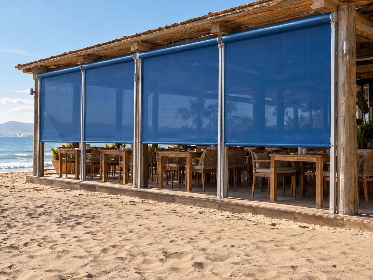 Toldo vertical para hostelería Toldos verticales de tejido azul dando sombra en un chiringuito de playa de la costa de Málaga