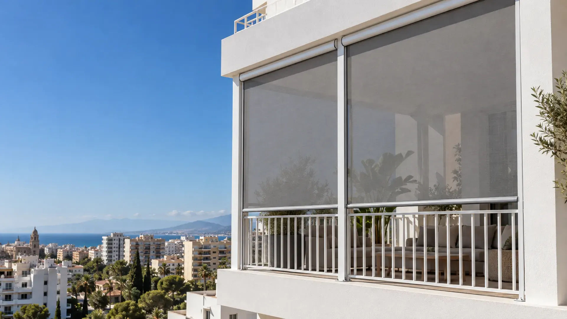 Toldo vertical en Málaga Toldo vertical en Málaga: toldos verticales de tejido screen gris bajados en la terraza de un piso con vistas al mar