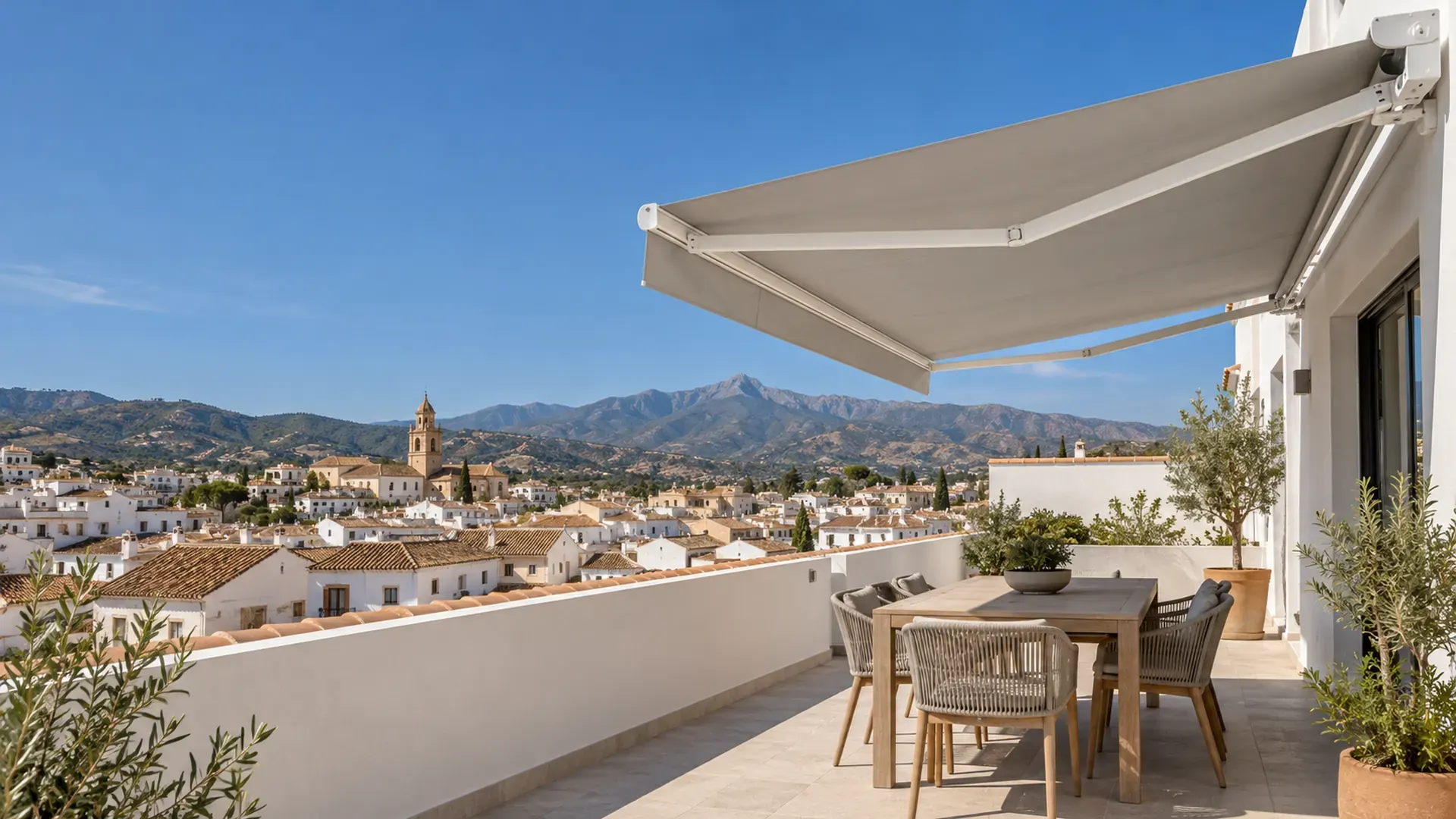 Toldos a medida en Málaga Toldos a medida en Málaga: toldo articulado con lona gris extendido en un ático de Vélez-Málaga con vistas al casco antiguo