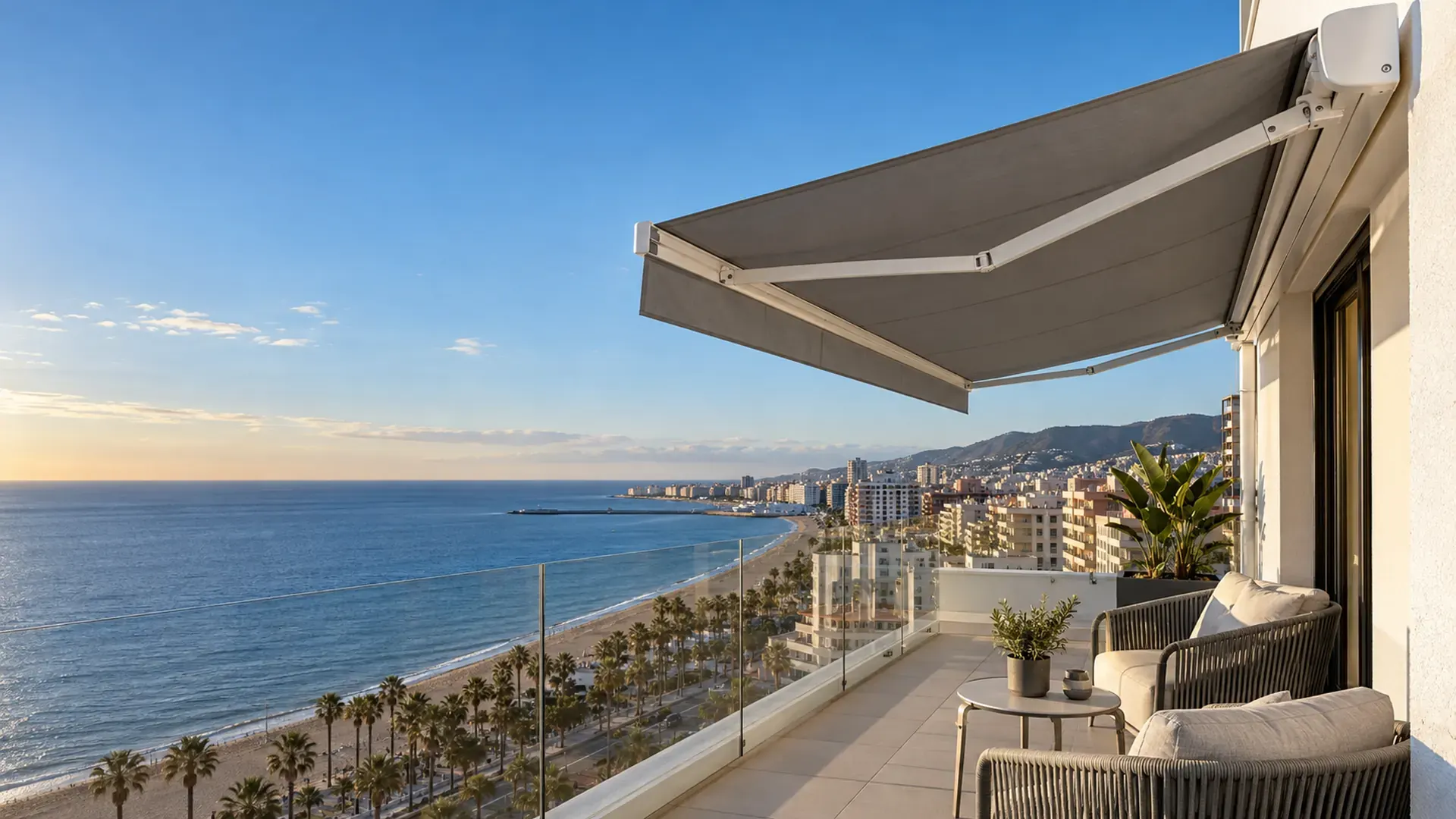 Toldos en Fuengirola Toldos en Fuengirola: toldo cofre con lona gris en la terraza de un piso con vistas a la playa y el paseo marítimo