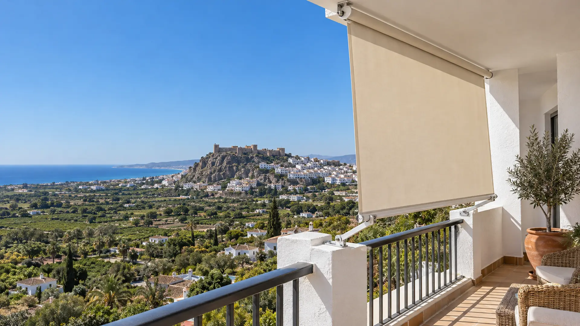 Toldos en Salobreña Toldos en Salobreña: toldo stor en la terraza de una casa blanca con vistas al castillo
